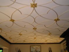 the ceiling in this living room is decorated with gold accents