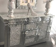 a mirrored sideboard with silver glitter shoes on top