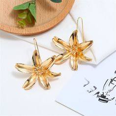 Bring blossoming bling to your earring rotation with these floral drops flaunting an 18k gold-plated hue for glamorous accessorizing. 2.17" W x 2.68" L 18k gold-plated copper Flower Drop Earrings, Flower Plates, Gold Tones, 18k Gold, Place Card Holders, Copper, Plating, Drop Earrings, Flowers