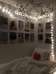 a bedroom with lights strung from the ceiling and pictures on the wall