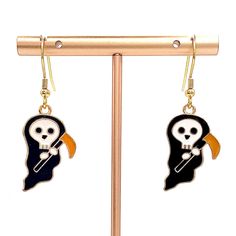 These Halloween dangle earrings feature a spooky design and are crafted with gold-finished stainless steel hooks. The charms are made with premium alloy plated with golden and colored enamel. Each pair is presented on a card and includes clear silicone backs for a secure fit. Due to differences in screen settings, colors may differ slightly between photos and the physical product. Please feel free to send me a message if you have questions regarding availability of patterns, quantities, or sizes. I often have patterns available that aren't listed yet! Halloween Dangle Metal Earrings, Metal Dangle Earrings For Halloween, Halloween Metal Drop Earrings, Halloween Novelty Drop Earrings Jewelry, Halloween Novelty Drop Earrings, Halloween Novelty Metal Earrings, Novelty Drop Earrings For Halloween, Halloween Gold Dangle Jewelry, Gold Dangle Halloween Jewelry