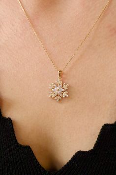 Embrace the enchanting beauty of winter with our captivating 14k gold snowflake pendant necklace. This exquisite piece features a meticulously crafted snowflake pendant adorned with shimmering zircon stones, capturing the magical essence of a winter wonderland. Made from high-quality 14k gold, our necklace is a testament to timeless elegance and durability. Snowflakes are a symbol of winter's beauty and uniqueness. Each snowflake is a masterpiece of nature, with its intricate design and delicate structure. Wearing our 14k gold snowflake necklace can be a reminder to appreciate the beauty of the natural world and the magic of winter. Our necklace is not just a beautiful piece of jewelry; it's also a symbol of hope and joy. The sparkle of the zircon stones and the delicate design of the snow Necklace Designs Aesthetic, Snowflake Pendant Necklace, Jewellery Necklace Design, Gold Necklace Pendant Design, Gold Snowflake Jewelry For Gifts, Gold Snowflake Jewelry Gift, Pendant Gold Design, Holiday Gold Snowflake Jewelry, Holiday Snowflake Shaped Gold Jewelry