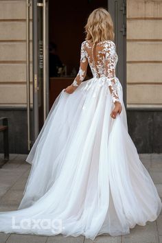 a woman in a white wedding dress is walking down the street with her back to the camera