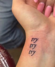 a woman's wrist tattoo with the words try try written in cursive writing