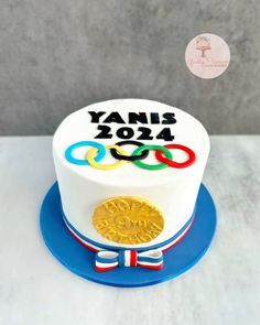 a cake with the olympic rings on it and a gold medal in front of it