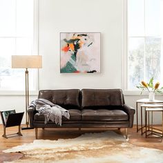 a living room filled with furniture and a painting on the wall