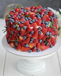 a cake covered in fresh berries and blueberries