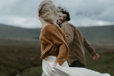 a man and woman are walking in the grass