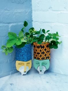 two planters with plants in them sitting next to each other