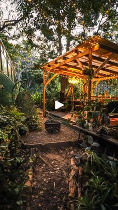 an outdoor area with lots of trees and plants in the background, including a covered patio