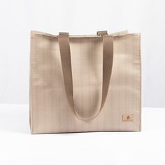 One of our most popular products, this shopper is perfect for almost anywhere you can imagine. This fabric is as robust as it gets. The bag is handcrafted from the excess material reclaimed from a high-end outdoor furniture company. Our customers love it for:- a work tote- a beach bag- a market tote- a mom bag (all the snacks and toys!)- a project bag- a library bag You can't go wrong! The bag features durable double straps that are the perfect length to tuck this bag right under your armBoth sturdy and elegant, this bag can be wiped down with a damp rag, hand sanitizer, or a disinfecting wipe. Take it to the gym, the beach, the store, and more. We're betting this is about to be your new favorite bag too. Details: 100% upcycled patio furniture fabric Dimensions: 18" x 6" x 12.5" Straps: Tw Mom Bag, Library Bag, Mom Bags, Grocery Items, Work Tote, Popular Products, Project Bag, Market Tote, Shopper Tote