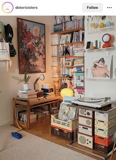 a living room filled with furniture and bookshelves next to a wall covered in pictures