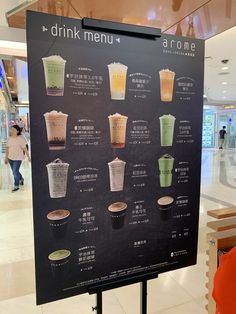 a menu board with drinks on it in a mall