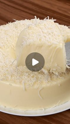 a cake with white frosting being cut by a knife