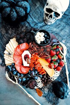 a platter with meats, cheeses, fruit and other foods on it