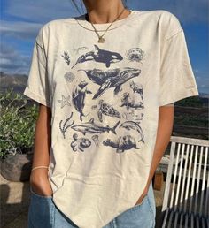 90s Tattoo Sea Animal Shirt, Vintage Dolphin Shirt, Retro Ocean Nature Shirt, Unisex Relaxed Adult Tee, Ocean Shirt, Whale Shirt, Sealife ⭐ INFORMATION: This unisex style t-shirt is suitable for both men and women. For care, wash the item inside out in cold water. Avoid bleach, dry cleaning, and direct ironing on the design. ⭐ MATERIAL DETAILS: Our heavyweight classic unisex tee is made from 5.3-ounce, 100% cotton, with variations of 99/1 cotton/poly (Ash) & 90/10 cotton/poly (Sport Grey). It fe Grunge Style Printed Short Sleeve Tops, Grunge Short Sleeve Printed Tops, Grunge Shirt With Funny Print For Summer, Summer Grunge Shirt With Funny Print, 90s Style Summer Shirt With Funny Print, Summer Grunge Short Sleeve Top, Summer Grunge Tops With Relaxed Fit, Summer Grunge Style Relaxed Fit Top, Grunge Tops With Funny Print For Summer