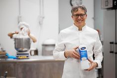 a smiling chef holding a bottle of water