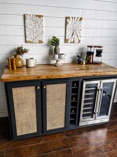 a kitchen island with two wine coolers on top and an oven in the middle