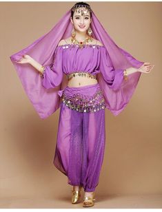 a woman in a purple belly dance outfit with her arms out and hands behind her head