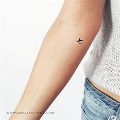 a woman's arm with a small airplane tattoo on the left side of her arm