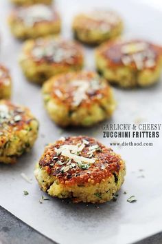 several crab cakes on a baking sheet with parmesan cheese and seasoning sprinkled on top