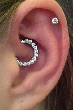 a woman's ear with two piercings on it