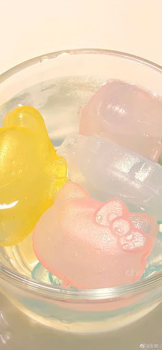 three soaps in a glass bowl on a white table top, one yellow and one pink