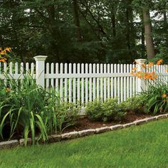 a white picket fence surrounded by lush green grass