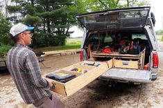 a man standing in the back of a van with his toolbox and tools inside