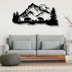 a living room with a couch, chair and wall hanging in the shape of mountains