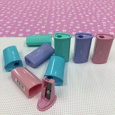 there are many different colored plastic cups on the table with pink and blue polka dots