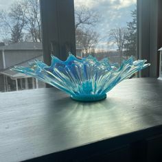 a blue glass bowl sitting on top of a wooden table