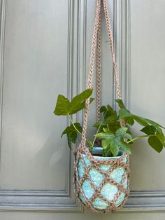 a potted plant hanging from the side of a door with chains attached to it