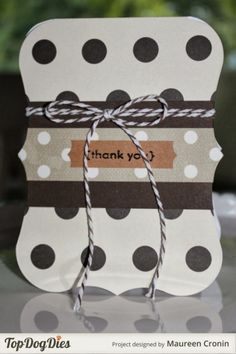 a thank you card with brown and white polka dots tied up to it's side