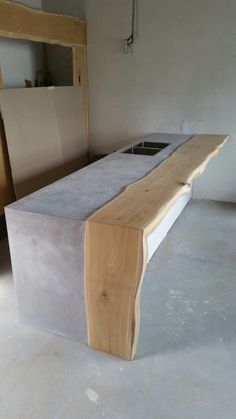 a bench made out of concrete and wood in a room with unfinished furniture on the floor