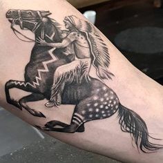 a tattoo on the arm of a person riding a horse