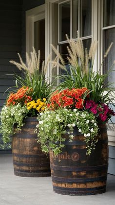 two wooden barrels filled with flowers and plants