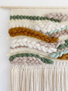 the wall hanging is decorated with different colored yarns