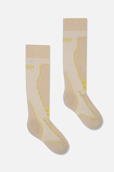 two pairs of white socks with yellow lines on the bottom and one pair of beige socks