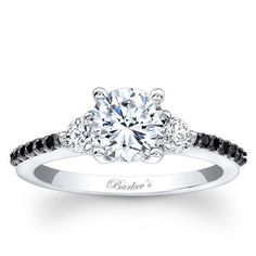 an engagement ring with black and white diamonds on the side, in front of a white background