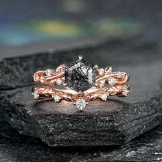 a diamond ring on top of a rock with diamonds in the center and leaves around it