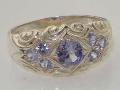 *This ring is made from 925 Sterling Silver with Natural Tanzanite.A beautiful Victorian Style Tanzanite Ring set with a center 4.5mm (0.18" inches)  and six 2.25mm (0.09" inches)  Tanzanites set in a gorgeous 925 Sterling Silver setting. PLEASE MAKE SURE YOU STATE THE FINGER SIZE YOU REQUIRE WITH YOUR PAYMENT AND PROVIDE YOUR TELEPHONE NUMBER FOR DELIVERY COURIER.This is a very comfortable and easy ring to wear being that it sits close to the finger, and the delightful carved design around the Silver Heirloom Gemstones For Anniversary, Wedding Silver Polished Gemstones, Tanzanite Rings With Polished Finish For Wedding, Polished Silver Gemstones For Wedding, Classic Silver Multi-stone Gemstones, Classic Silver Amethyst Ring With Multi-stone, Classic Multi-stone Topaz Ring Gift, Silver Tanzanite Round Stone Jewelry, Wedding Tanzanite Jewelry With Polished Finish