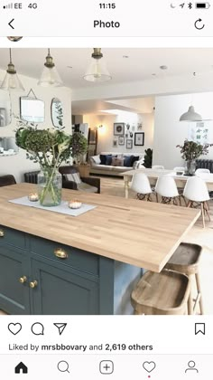 a kitchen island with flowers in a vase sitting on it's counter top next to chairs