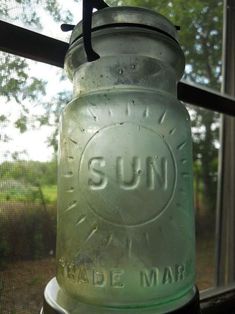 a glass jar sitting on top of a window sill next to a screen door