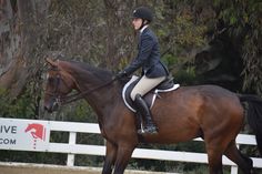 a woman riding on the back of a brown horse