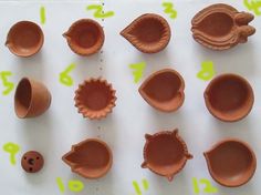 several clay bowls and cups are shown on a table with numbers written in green ink