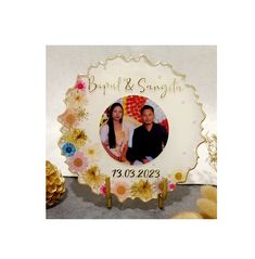 a wedding photo frame with flowers and pine cones