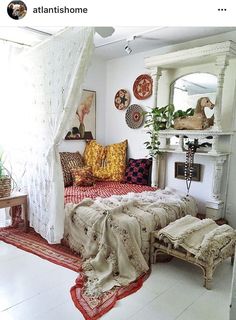 a bedroom with white walls and lots of pillows on the bed in front of it