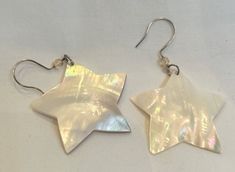 "These White Mother of Pearl Star Shaped Earrings will be the star of your earring show! They are lightweight and comfortable to wear as they dangle from your earlobes and light up your beautiful, happy face. Shiny & irridescent, these shell star earrings will make any outfit feel special.  Measures 1 3/4\" star tip to star tip. Silver Earwires" White Star-shaped Earrings For Wedding, White Star-shaped Earrings As Gift, Star-shaped White Pearl Earrings For Gift, White Starfish Charm Star Earrings, White Star-shaped Earrings With Star Charm, White Starfish Charm Earrings, White Shell-shaped Mother Of Pearl Earrings, Shell Earrings, Star Earrings