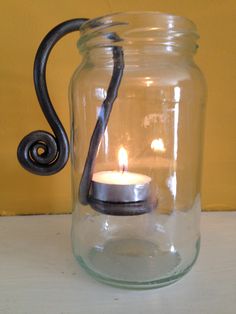 a glass jar with a candle in it